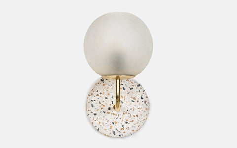 Eros White Wall Lamp with Terrazzo base, Gold-finished Mild Steel, and Frosted Glass shade.  This lamp is available online in India.